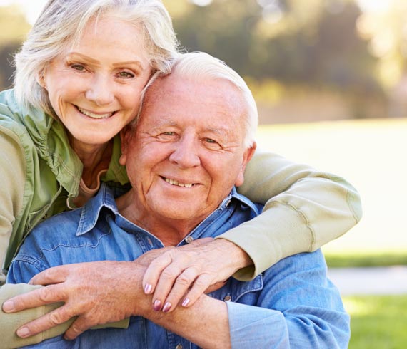 Image of smiling senior couple embracing each other.