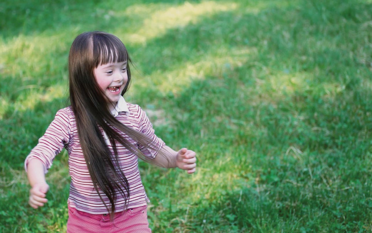 Toddler running in lawn.